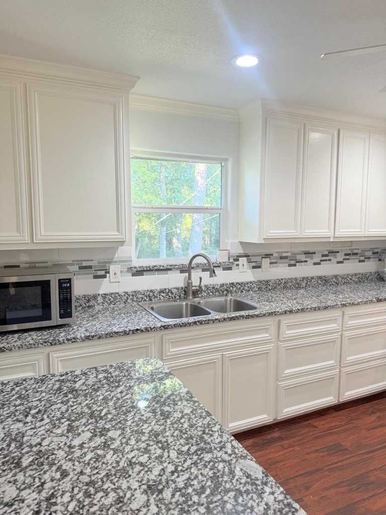 304 Jill Street Conroe, TX 77303 - Photo 8 of 35 a kitchen with granite countertop a sink and a stove