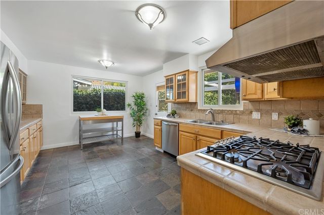a kitchen with stainless steel appliances a stove a sink and a refrigerator