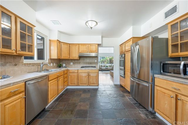 a large kitchen with stainless steel appliances granite countertop a refrigerator and a sink
