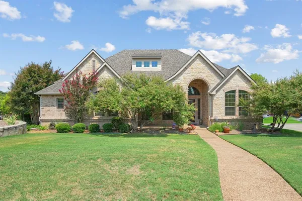 a front view of a house with a yard and trees