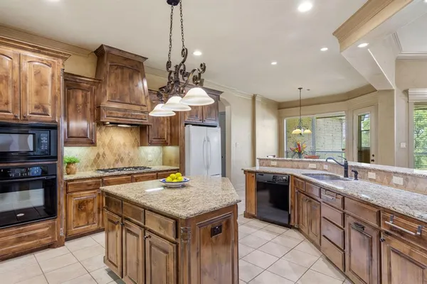a kitchen with kitchen island granite countertop a sink stove and refrigerator