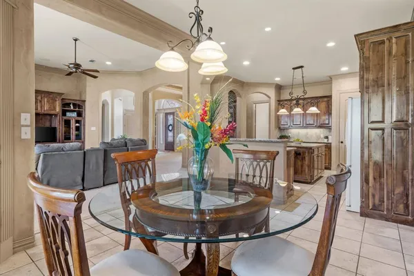 a dining room with furniture a chandelier and kitchen view