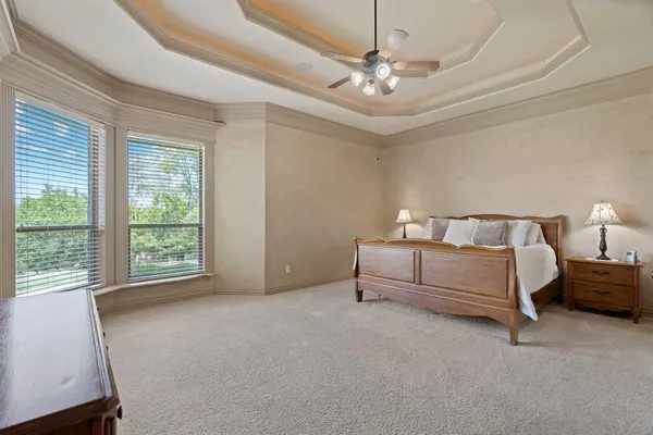 a spacious bedroom with a bed and a chandelier