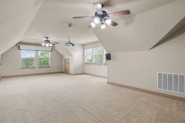 en empty room with windows and ceiling fan