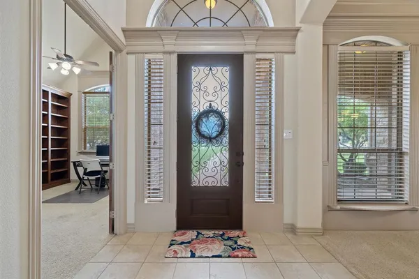 a view of a hallway with wooden door and windows
