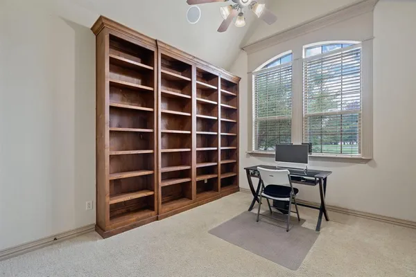 a view of a workspace with furniture and a window