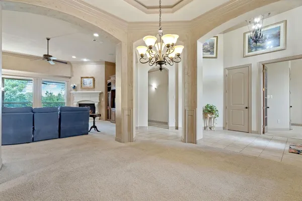 a view of a livingroom with a chandelier fan and windows