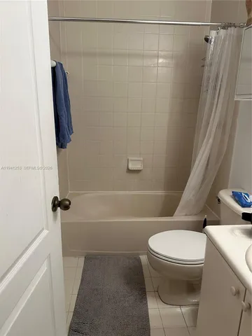 a white toilet sitting next to a bath tub