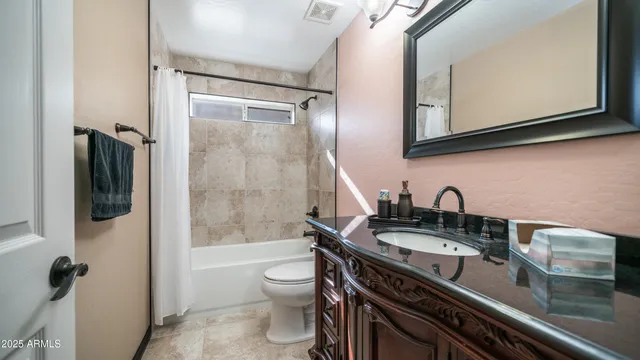 a bathroom with a granite countertop sink a toilet a mirror and bathtub