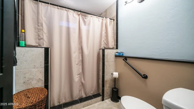 a bathroom with a toilet and a shower curtain