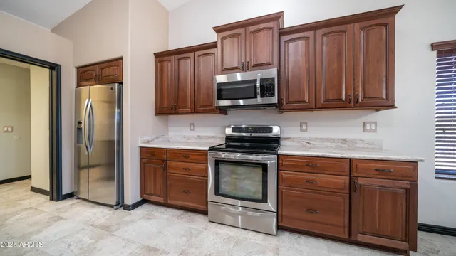 a kitchen with stainless steel appliances granite countertop a refrigerator stove and sink