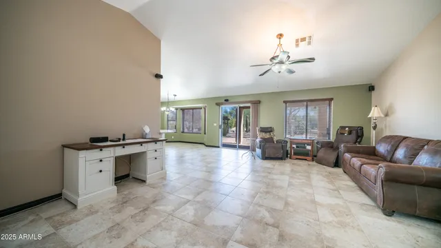 a living room with furniture a chandelier and kitchen view