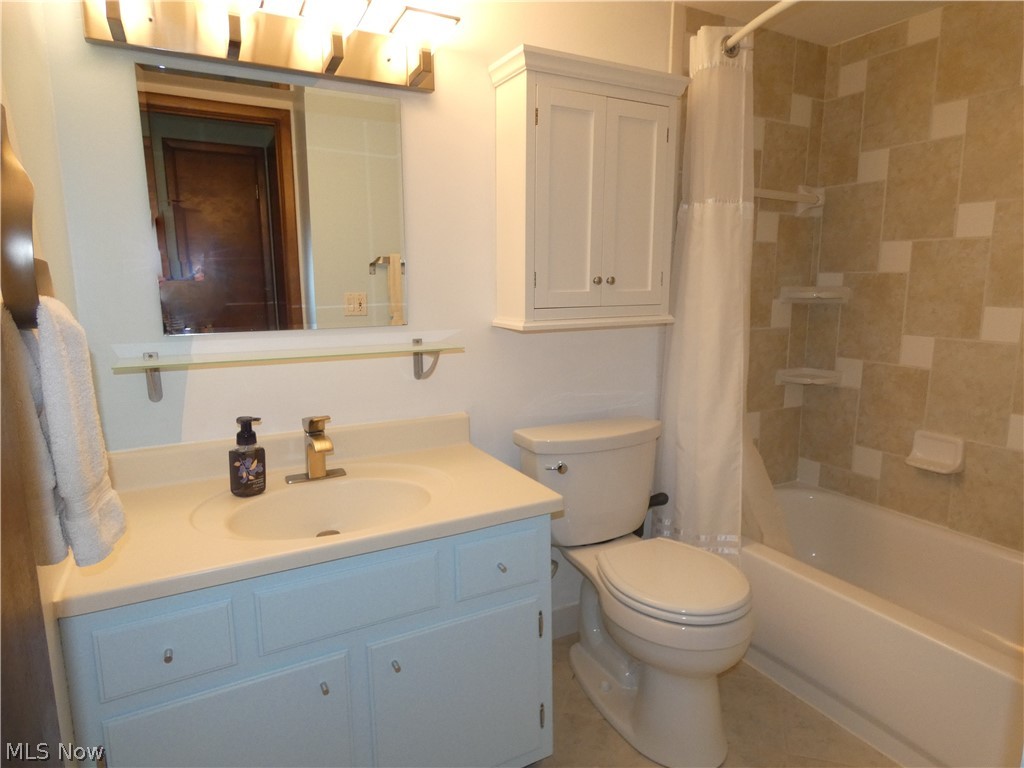 10740 Valley View Road, Unit 2A Northfield, OH 44067 - Photo 10 of 19 Bathroom features ceramic flooring and shower surround with brushed nickel plumbing fixture and towel racks.