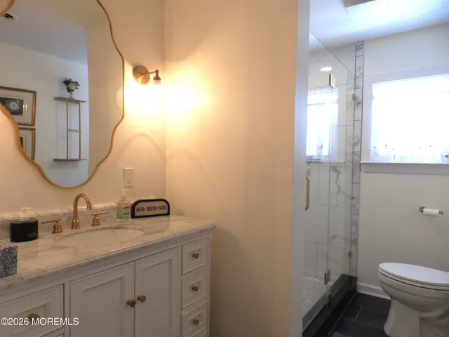 a bathroom with a granite countertop sink toilet and shower