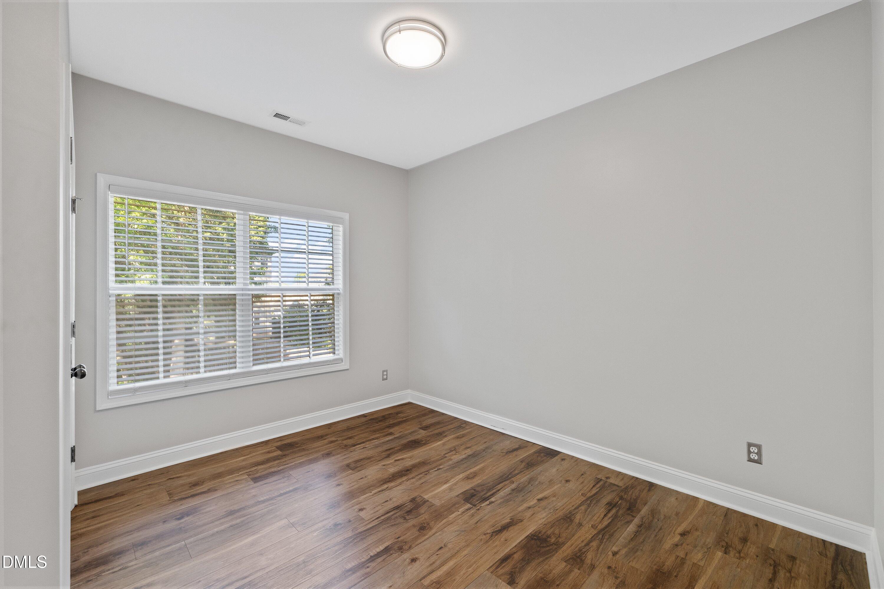 3717 Windmeade Road Wake Forest, NC 27587 - Photo 25 of 51 an empty room with wooden floor and windows