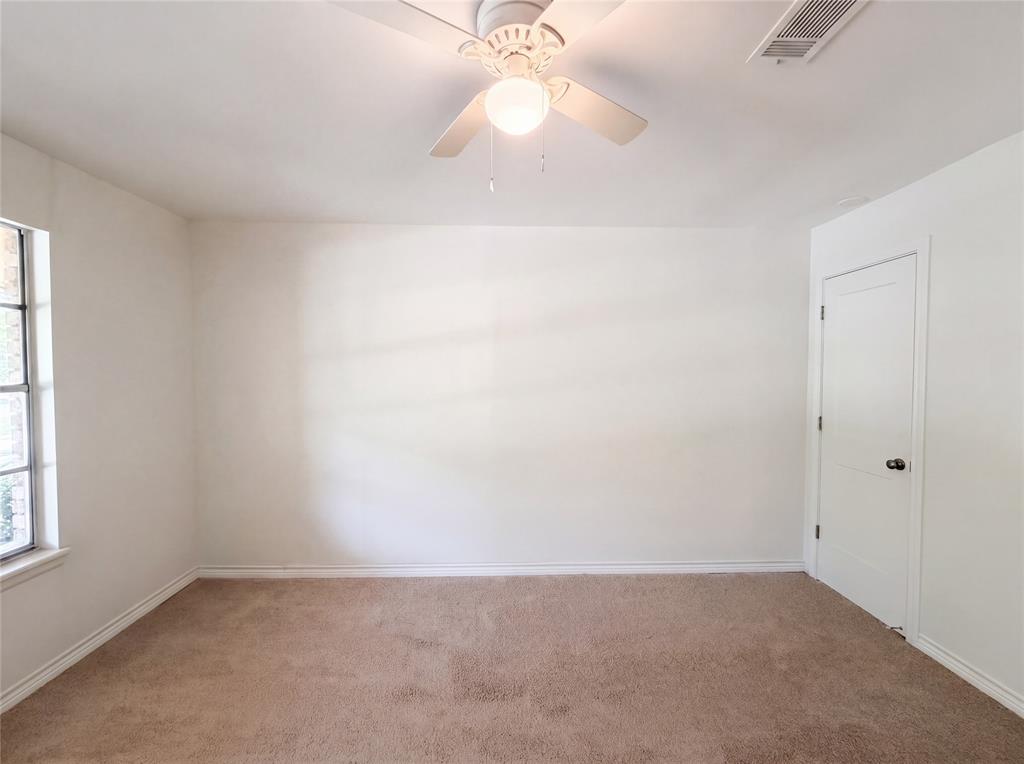 205 West Decatur Street Chico, TX 76431 - Photo 9 of 19 an empty room with a chandelier fan and windows