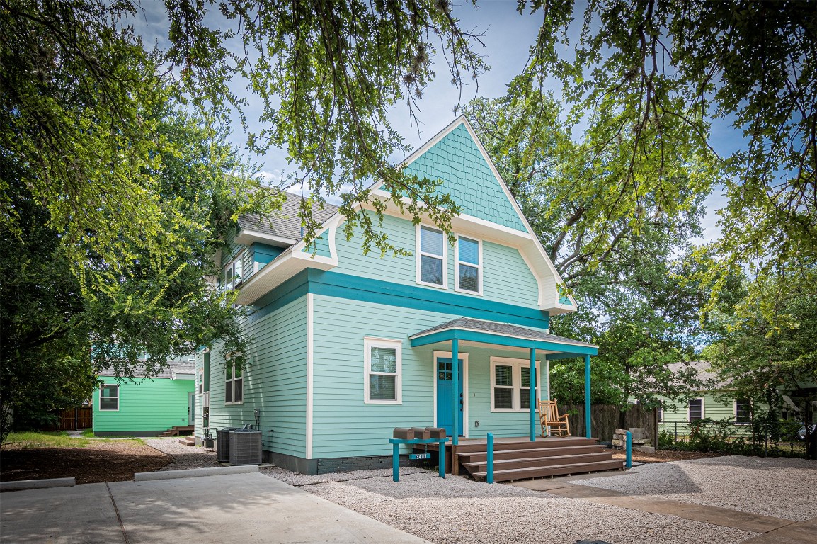 a view of a house with a tree in front of it
