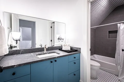 a spacious bathroom with double vanity a toilet a sink and a mirror