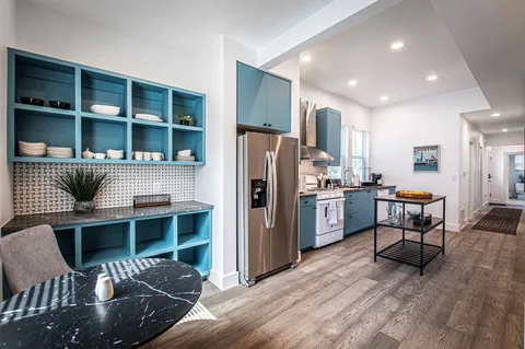 a kitchen with stainless steel appliances granite countertop sink stove and wooden floor
