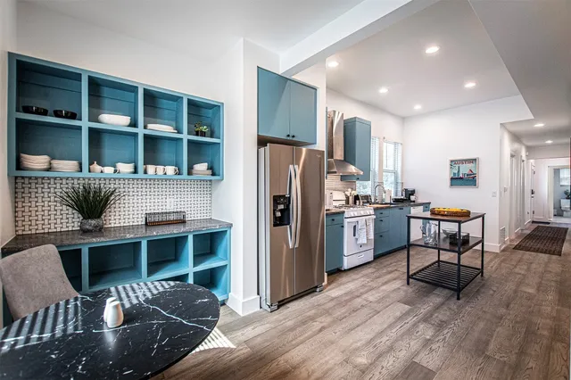 a kitchen with stainless steel appliances granite countertop sink stove and wooden floor