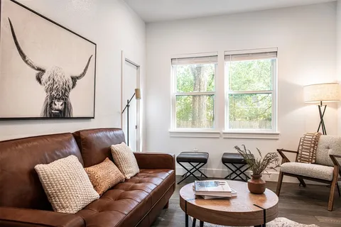 a living room with furniture a flat screen tv and kitchen view