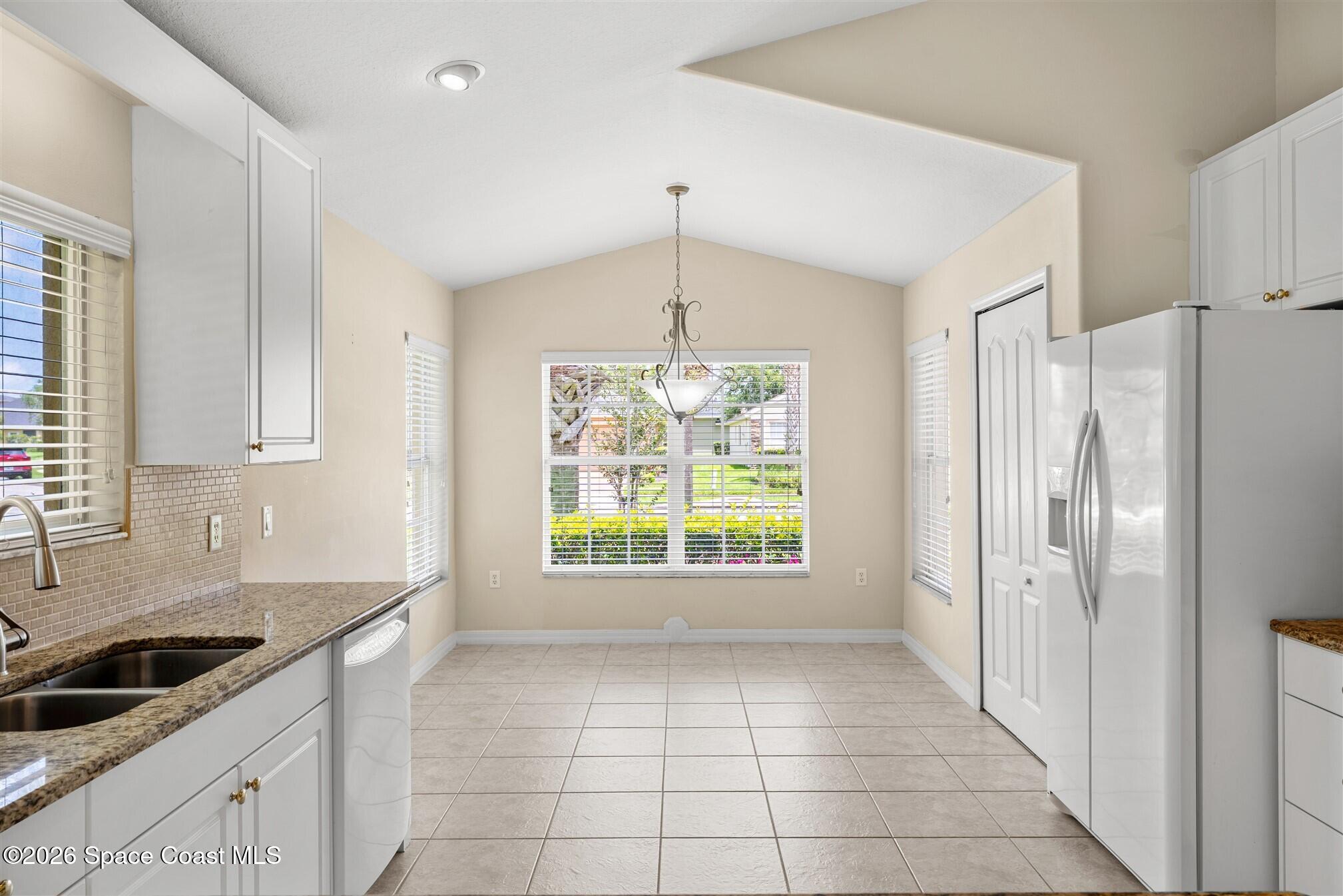 6904 Renshaw Drive Melbourne, FL 32940 - Photo 4 of 46 a kitchen with granite countertop a refrigerator and a sink