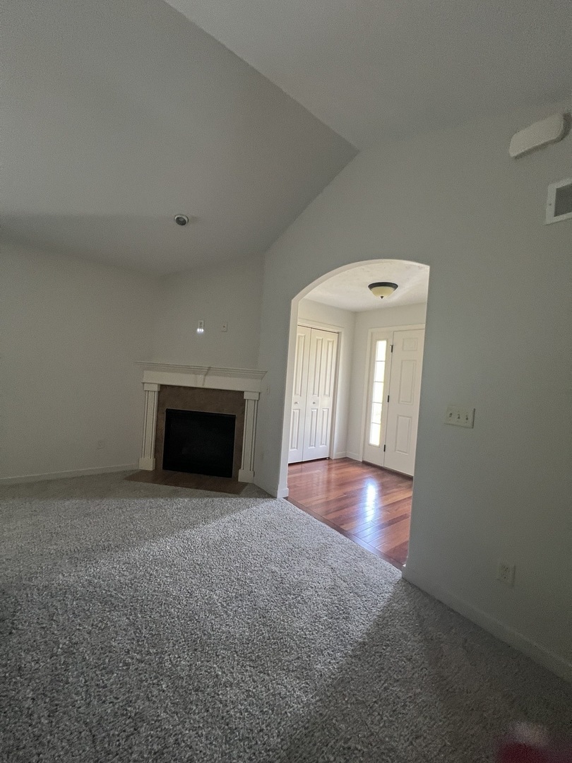 1647 Belclare Road Normal, IL 61761 - Photo 4 of 14 an empty room with wooden floor and fireplace