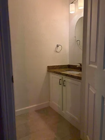 a bathroom with a granite countertop sink and mirror