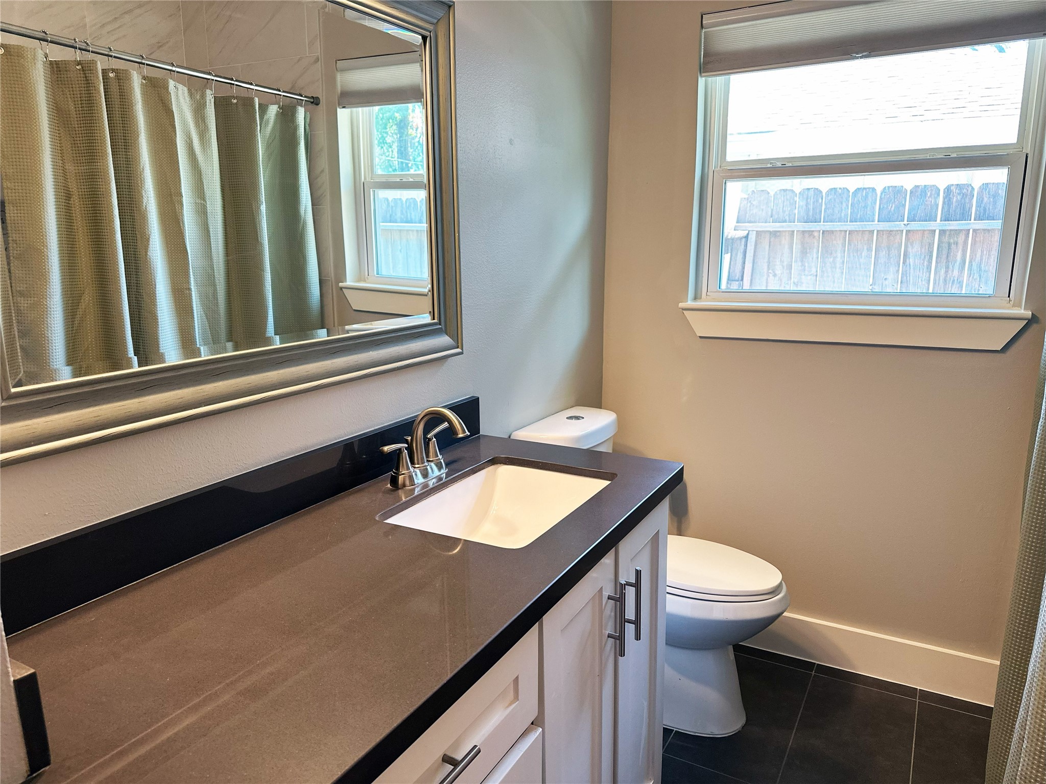 4821 Hummingbird Street Houston, TX 77035 - Photo 28 of 45 a bathroom with a granite countertop toilet sink and mirror