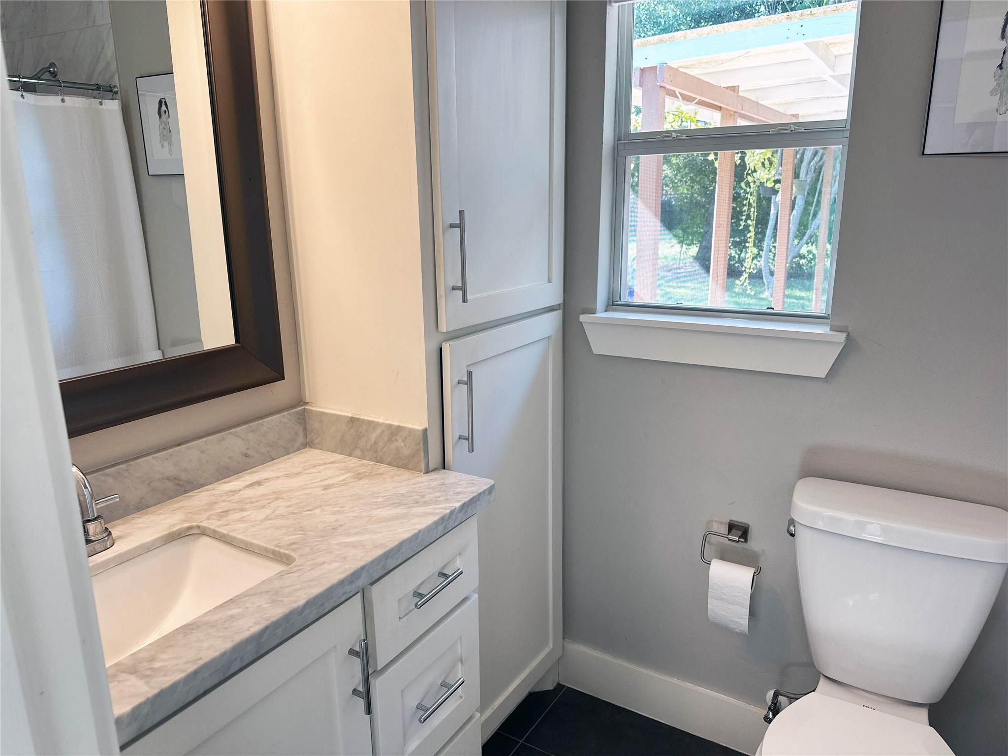 4821 Hummingbird Street Houston, TX 77035 - Photo 37 of 45 a bathroom with a granite countertop toilet sink and a window