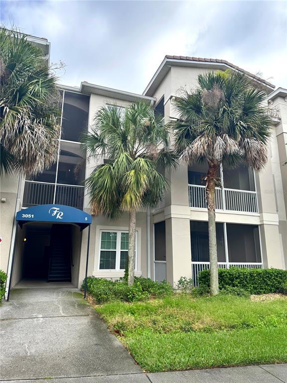 3051 Greystone Loop, Unit 306 Kissimmee, FL 34741 - Photo 1 of 27 a front view of a house with a garden