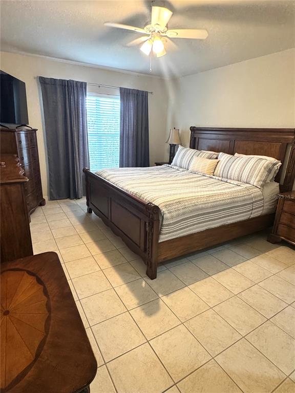 3051 Greystone Loop, Unit 306 Kissimmee, FL 34741 - Photo 17 of 27 a spacious bedroom with a bed and a chandelier