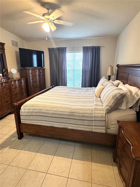3051 Greystone Loop, Unit 306 Kissimmee, FL 34741 - Photo 18 of 27 a bedroom with a bed and a television
