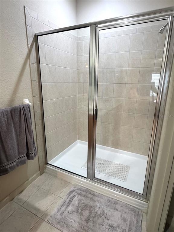 3051 Greystone Loop, Unit 306 Kissimmee, FL 34741 - Photo 20 of 27 a bathroom with a glass shower door