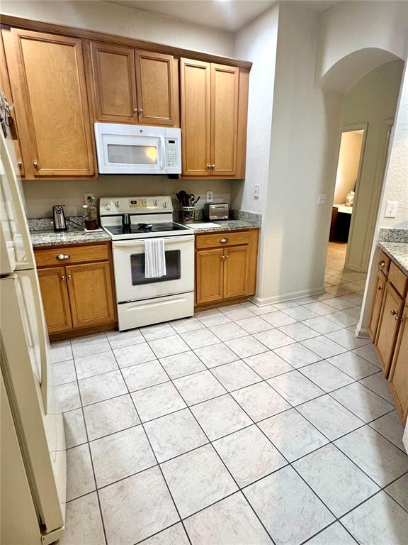 3051 Greystone Loop, Unit 306 Kissimmee, FL 34741 - Photo 7 of 27 a kitchen with stainless steel appliances a stove a sink and a microwave