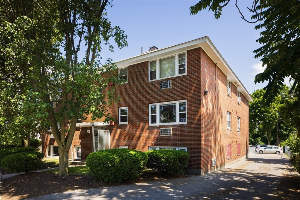 206 High Street, Unit 7 Waltham, MA 02453 - Photo 16 of 17 a front view of a house with a yard