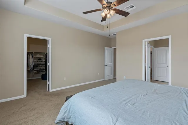 a view of a bedroom with a ceiling fan