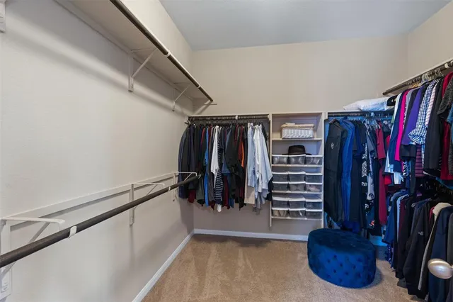 a view of walk in closet with clothes and shoes