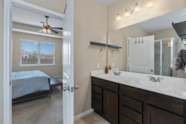 a en suite bathroom with a double vanity sink a mirror and shower