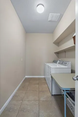 a utility room with a sink a cabinetry and a window
