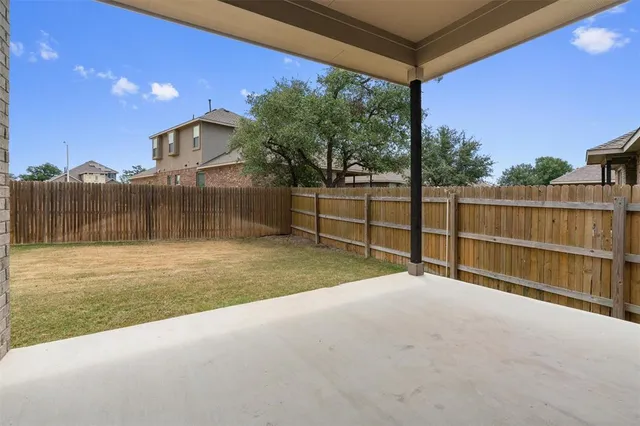 a view of backyard with wooden fence