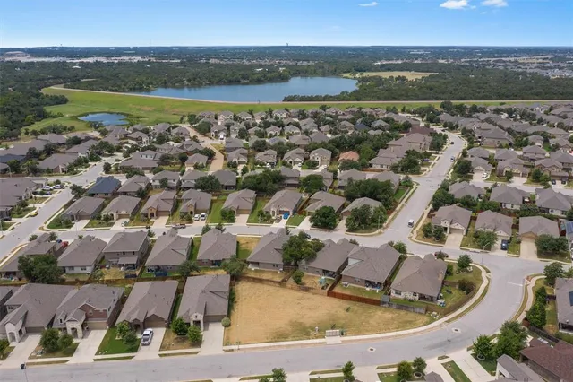 an aerial view of residential houses with outdoor space and ocean