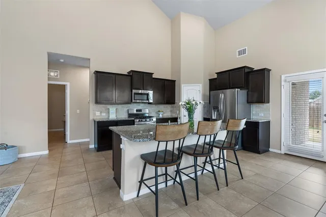 a kitchen with stainless steel appliances a refrigerator and a stove top oven