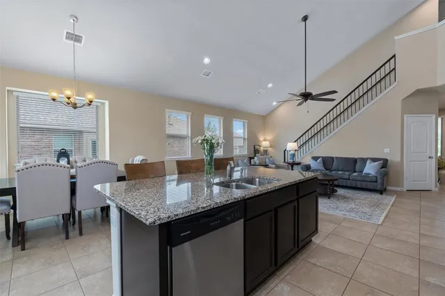 a kitchen with a counter a sink and chairs