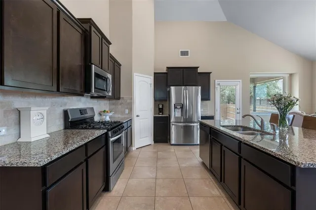 a kitchen with stainless steel appliances granite countertop a sink stove and refrigerator