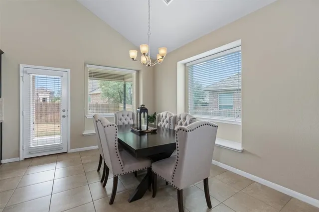 a dining room with furniture a chandelier and window
