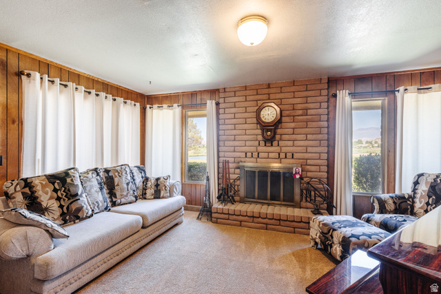 1470 Redwood Tree Street St. George, UT 84790 - Photo 25 of 53 Living area featuring a brick-surround fireplace with a metal screen, wood-panel walls, and neutral carpeting