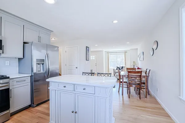 a kitchen with a table chairs refrigerator and cabinets