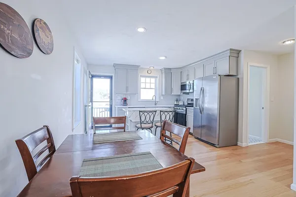 a living room with furniture a large window and stainless steel appliances