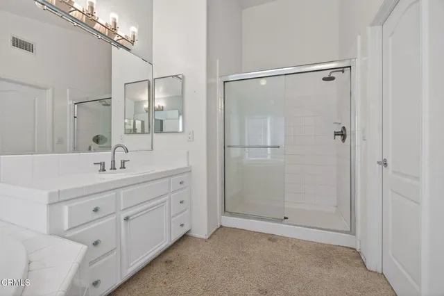 a bathroom with a shower sink and mirror